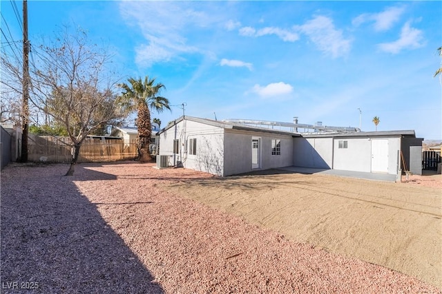 rear view of property with central AC unit, fence, a patio, and stucco siding