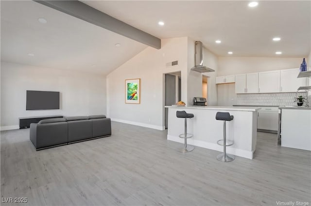 living room featuring light wood finished floors, baseboards, visible vents, lofted ceiling with beams, and recessed lighting