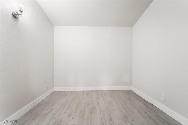 spare room featuring wood finished floors and baseboards