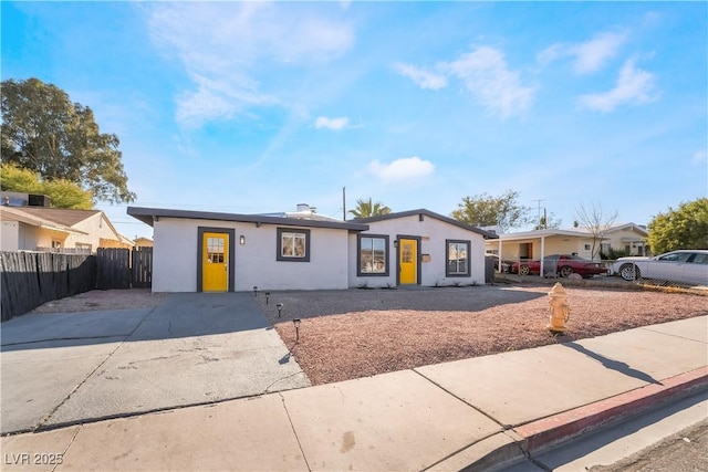 ranch-style home with fence and stucco siding