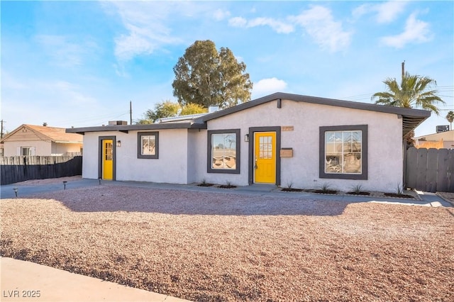 ranch-style house with fence and stucco siding