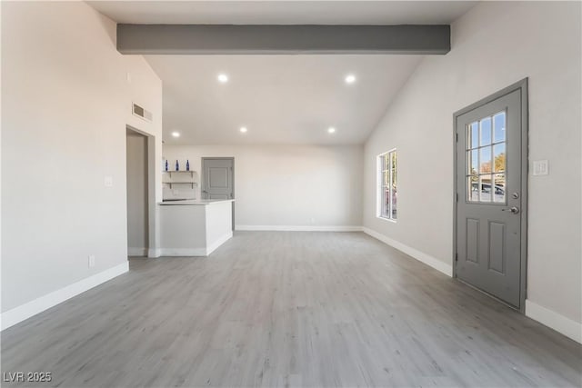 unfurnished living room featuring visible vents, beamed ceiling, light wood-style flooring, and baseboards