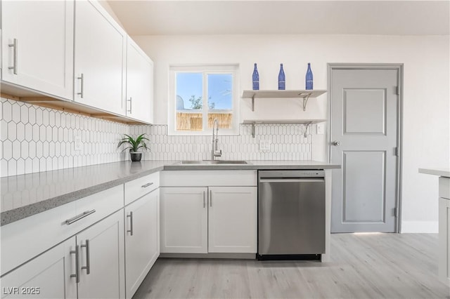 kitchen featuring a sink, white cabinetry, light wood-type flooring, backsplash, and dishwasher