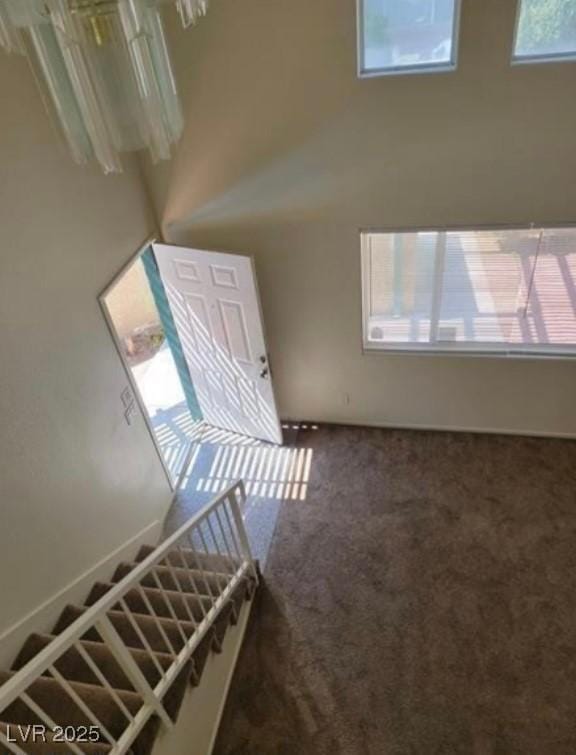 foyer with carpet, a high ceiling, and stairs