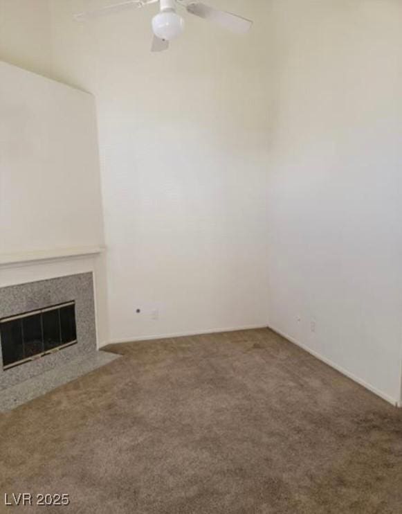 unfurnished living room with a fireplace, a ceiling fan, and carpet flooring