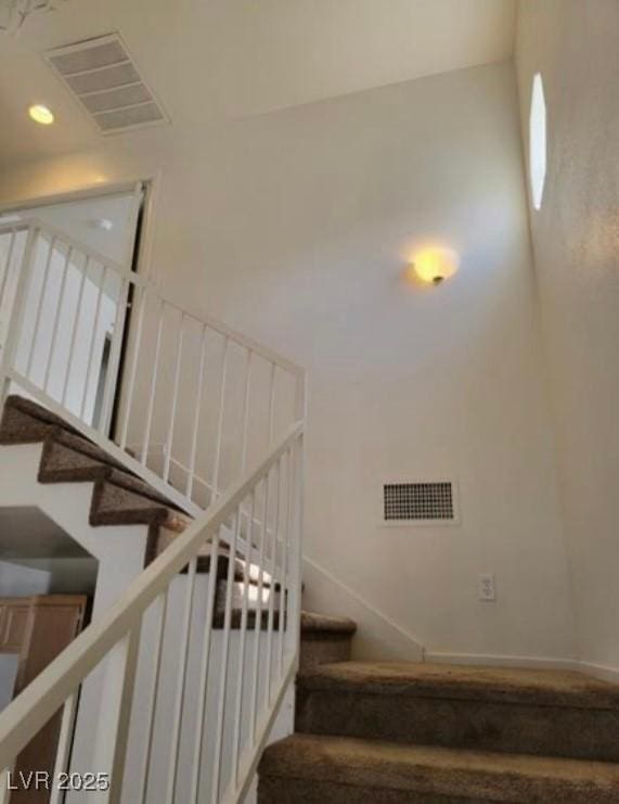 staircase with visible vents and recessed lighting