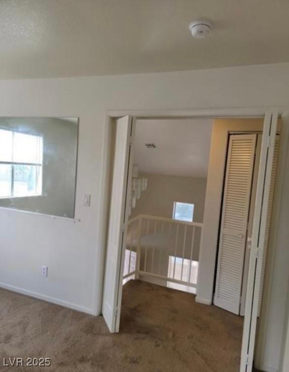 empty room featuring baseboards and carpet flooring