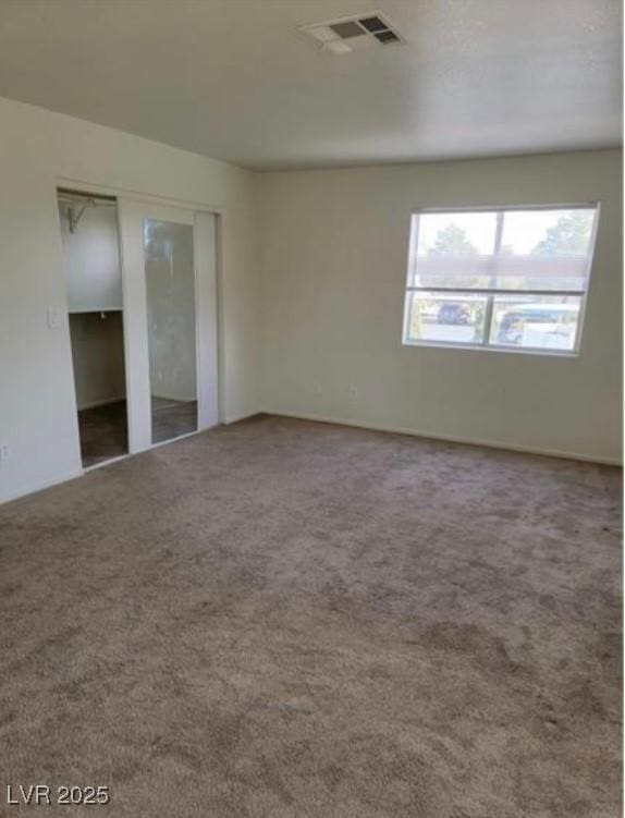 carpeted spare room featuring visible vents