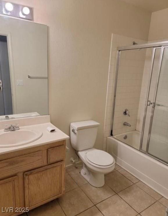 bathroom featuring bath / shower combo with glass door, vanity, toilet, and tile patterned floors