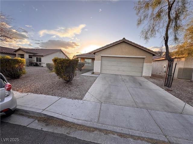 ranch-style house featuring an attached garage, cooling unit, a tile roof, concrete driveway, and stucco siding