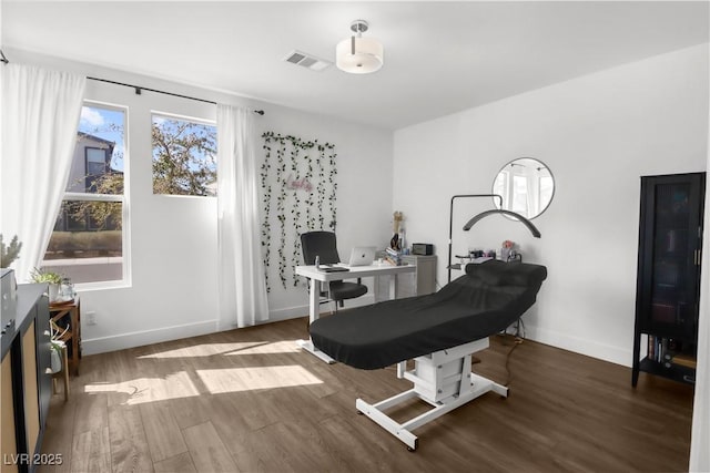 interior space featuring visible vents, baseboards, and wood finished floors