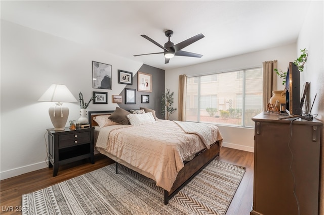 bedroom featuring ceiling fan, baseboards, and dark wood finished floors