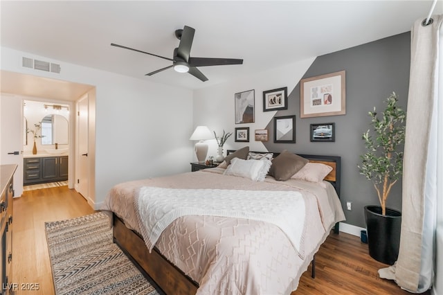 bedroom with baseboards, visible vents, a ceiling fan, connected bathroom, and light wood-type flooring