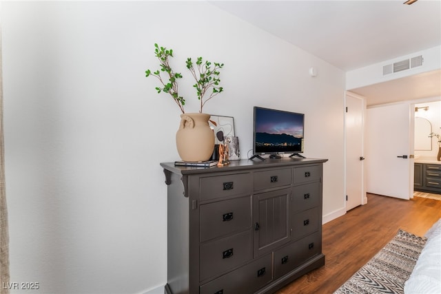 interior space with wood finished floors and visible vents