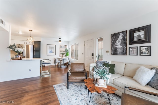 living room featuring dark wood-style floors, ceiling fan, and baseboards