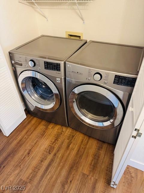 washroom with laundry area, washer and dryer, and wood finished floors