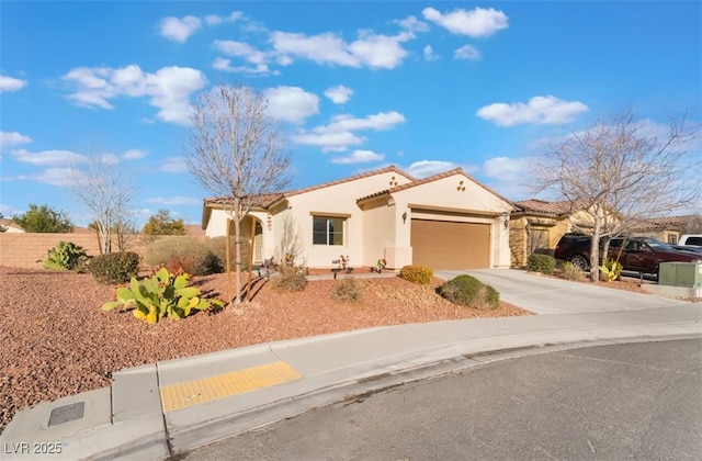 mediterranean / spanish home with stucco siding, concrete driveway, fence, a garage, and a tiled roof