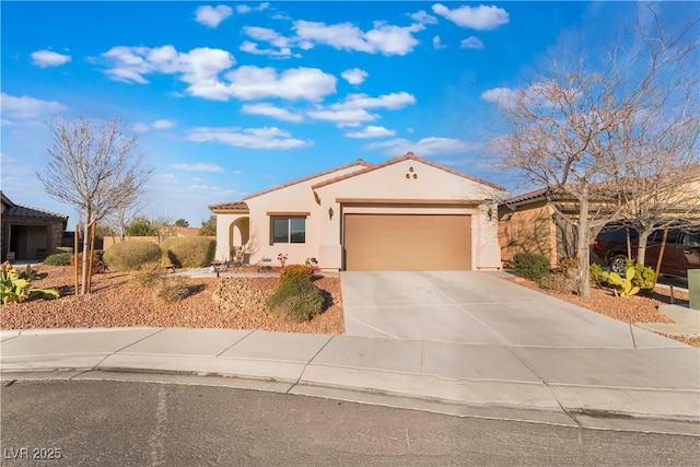 mediterranean / spanish house featuring a garage, concrete driveway, a tile roof, and stucco siding