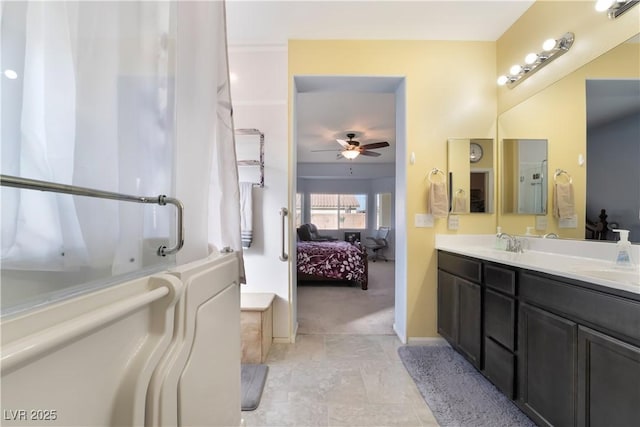 ensuite bathroom featuring ceiling fan, connected bathroom, a sink, a bath, and double vanity