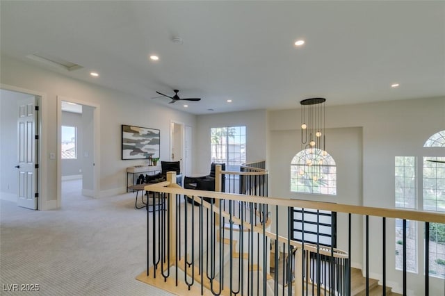 hallway featuring carpet floors, an upstairs landing, baseboards, and recessed lighting