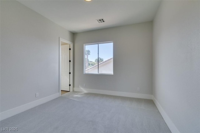 carpeted empty room featuring baseboards and visible vents