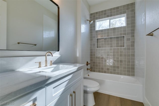 full bathroom with toilet, washtub / shower combination, wood finished floors, and vanity