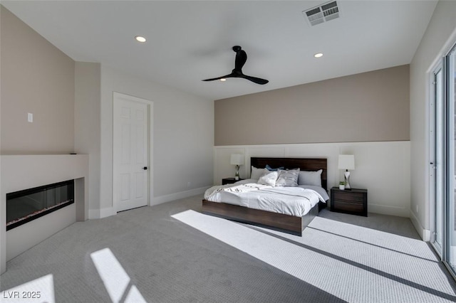 carpeted bedroom featuring ceiling fan, recessed lighting, visible vents, baseboards, and a glass covered fireplace