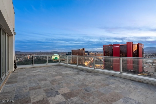 patio terrace at dusk featuring a city view