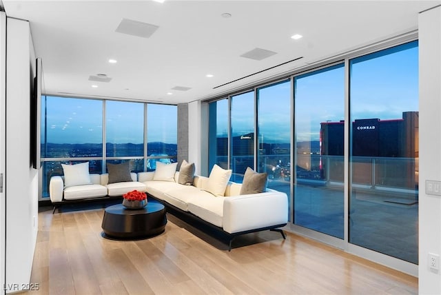 living room featuring recessed lighting, wood finished floors, and floor to ceiling windows