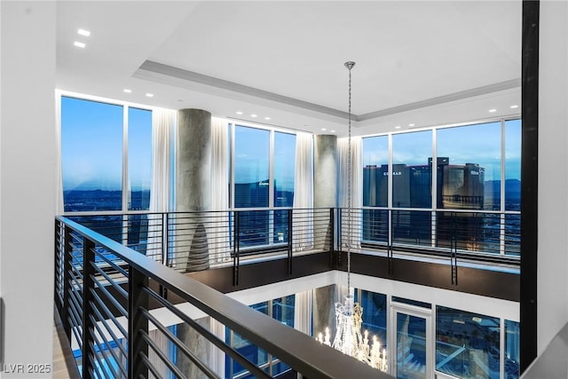 hall featuring a tray ceiling and recessed lighting