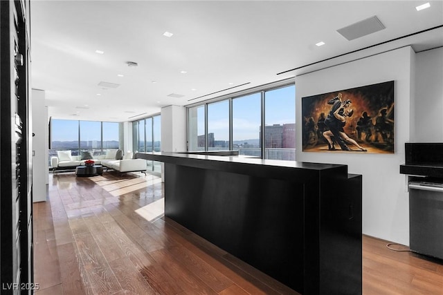 kitchen with open floor plan, floor to ceiling windows, a city view, and wood finished floors