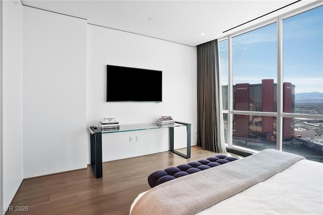 bedroom with expansive windows and wood finished floors