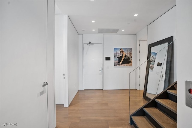 corridor featuring stairway, light wood-style flooring, and recessed lighting