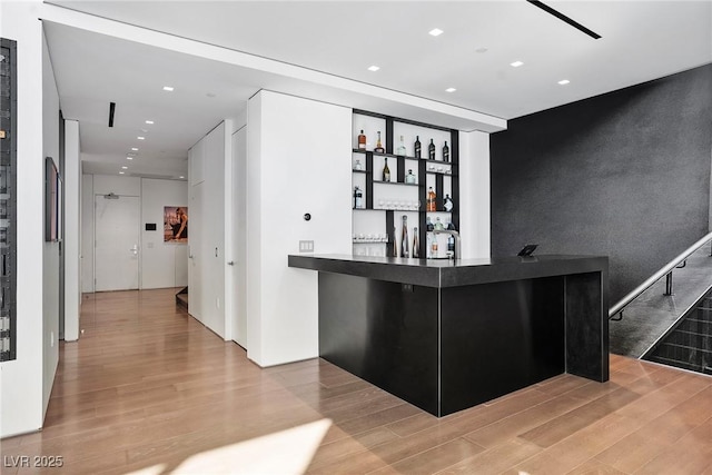 bar with recessed lighting, a dry bar, and wood finished floors