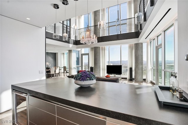 kitchen with a wealth of natural light, dark countertops, open floor plan, and wine cooler