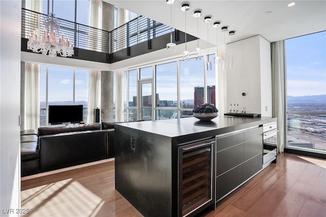 kitchen with plenty of natural light, wine cooler, and wood finished floors