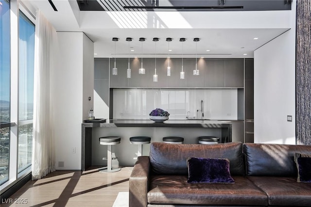 living room featuring wet bar, a healthy amount of sunlight, and recessed lighting