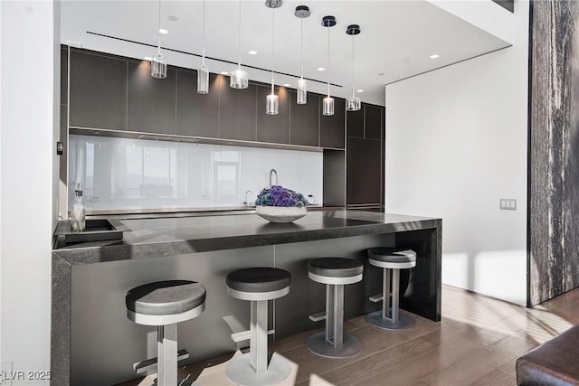 bar featuring wet bar, pendant lighting, and wood finished floors