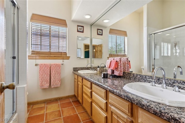 full bath featuring double vanity, a sink, a shower with door, and tile patterned floors