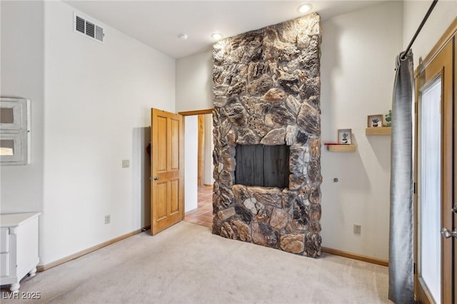 living area with light carpet, visible vents, and baseboards