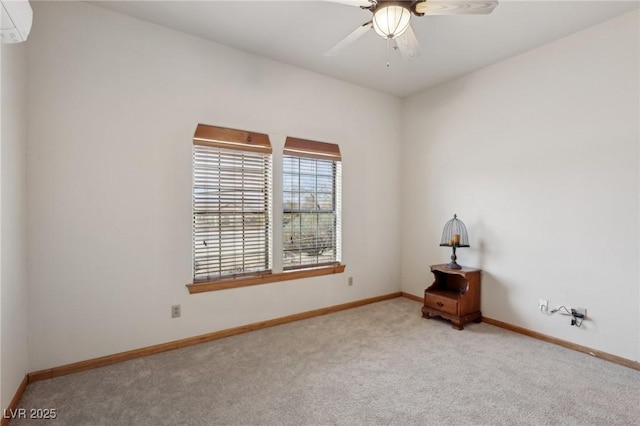 unfurnished room featuring a ceiling fan, light colored carpet, a wall unit AC, and baseboards