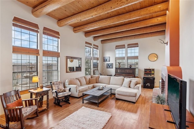 living area featuring wooden ceiling, a fireplace, beam ceiling, and wood finished floors