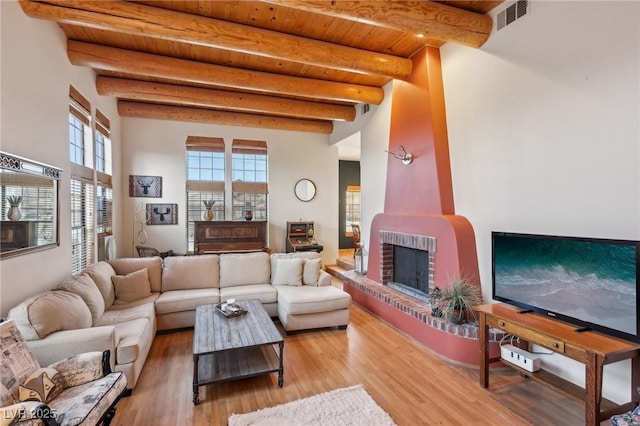 living room with wood ceiling, visible vents, beamed ceiling, and light wood finished floors