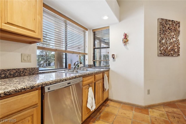 kitchen featuring stone counters, recessed lighting, stainless steel dishwasher, a sink, and baseboards