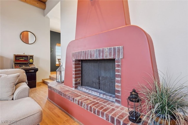 living room featuring a brick fireplace and wood finished floors