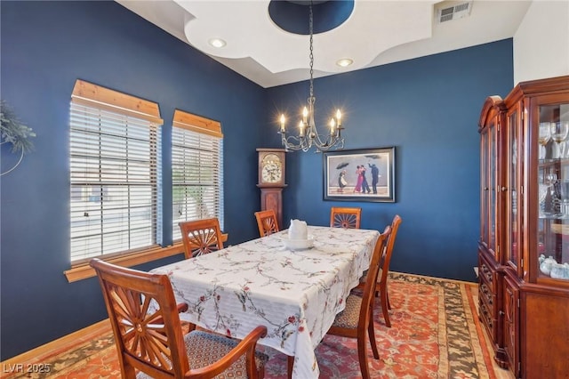 dining room featuring baseboards, visible vents, and a notable chandelier