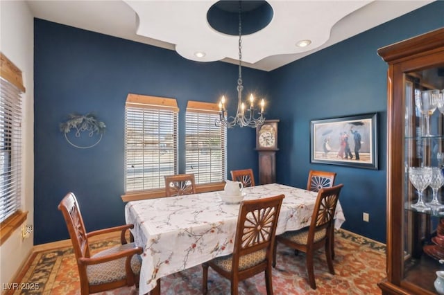 dining room featuring a chandelier and baseboards