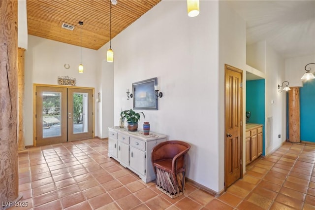 entrance foyer with french doors, light tile patterned floors, visible vents, wood ceiling, and high vaulted ceiling