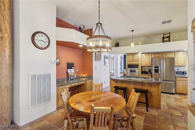 dining space with lofted ceiling, stone finish floor, visible vents, and a chandelier