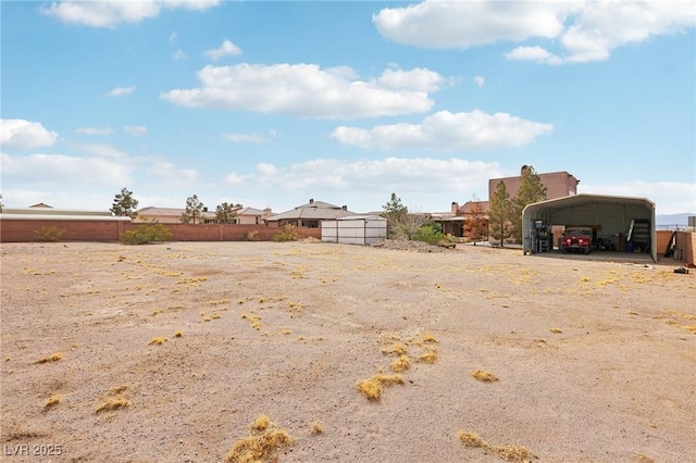 view of yard with fence and a carport